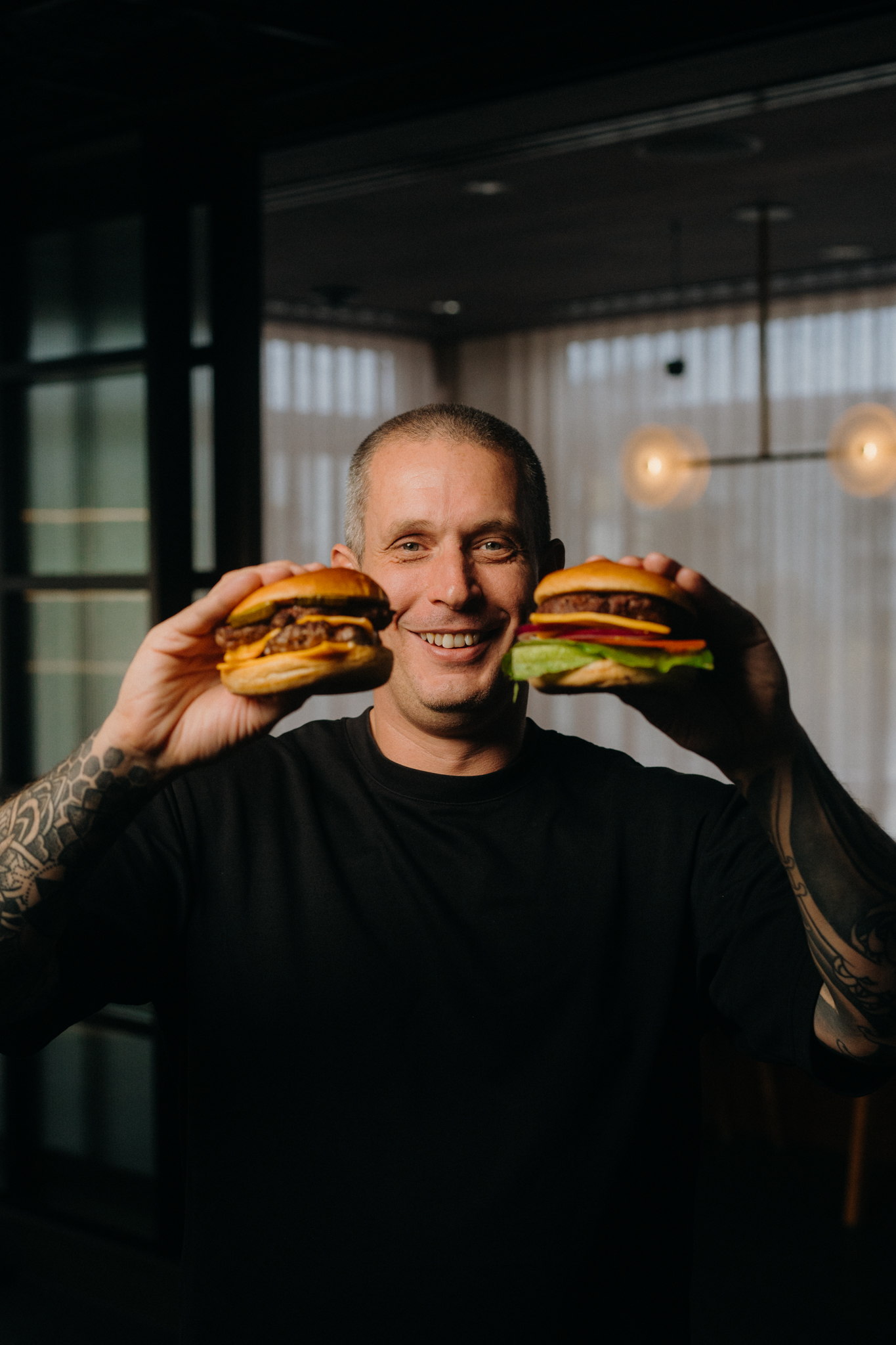 Andy-cooks holding two few and far burgers